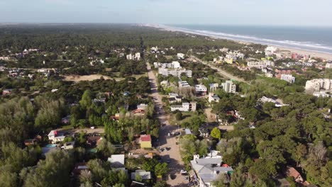 Aerial-view-of-Main-Road-of-Mar-de-las-Pampas-during-sunny-day-with-beach-and-ocean-in-background,Argentina