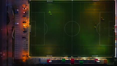 Straight-down-shot-of-a-football-field-in-the-dark-with-lights-sliding-right-in-Santa-Ponsa,-Mallorca,-Spain