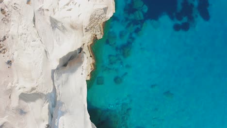 Sarakiniko-Beach-Coastline,-geology-rhyolitic-white-rocks,-overhead-aerial