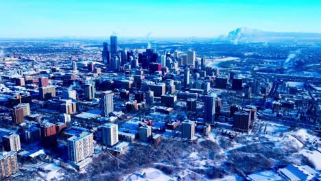 Edmonton-Downtown-Aerial-Flyover-City-from-the-West-to-East-in-Extreme-Cold-Temperatures-of--22F-or--30c-from-the-river-valley-to-the-skyscrapers-where-heater-white-smoke-blowing-out-of-every-building