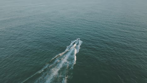 Aerial-video-of-a-drone-flying-in-close-to-a-speeding-boat-on-the-ocean