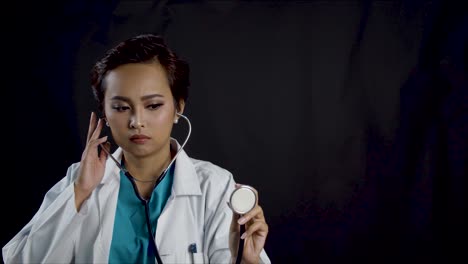 Female-doctor-holds-up-a-stethoscope-during-a-physical-examination-as-if-she-is-listening-to-a-patients-heart-and-lungs---copy-space