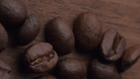 Produktaufnahme-Von-Kaffeebohnen,-Die-Auf-Einen-Holztisch-Fallen