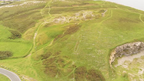 Great-orme-summit-aerial-view-hill-of-names-hillside-stone-words-attraction-pull-back-reveal