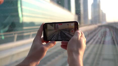 Tourist-Mit-Smartphone-Aufnahmevideo-Der-Eisenbahn-Von-Dubai-Metro-Von-Der-Vorderseite-Des-Fahrenden-Zuges-60fps