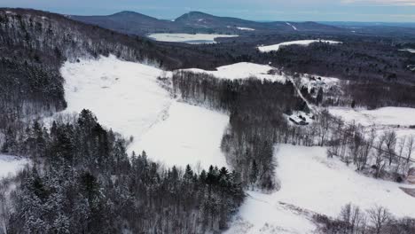 Luftaufnahmen,-Die-Hoch-über-Mehrere-Schneebedeckte-Felder-An-Der-Seite-Eines-Hügels-Fliegen