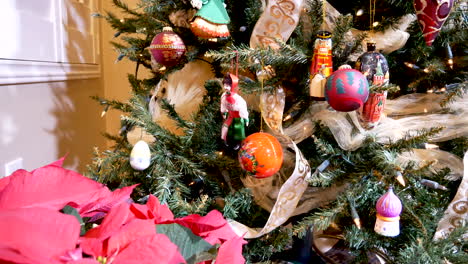 Poinsettia-En-Primer-Plano-Mientras-Deslizamos-Hacia-Arriba-Un-árbol-De-Navidad-Decorado