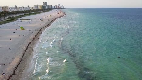 Aerial-view-overlooking-calm-waves-and-people-at-the-South-beach,-in-Miami,-USA