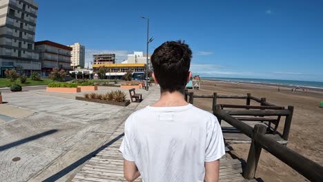 Blick-Hinter-Einen-Jungen-Mann,-Der-In-Der-Stadt-Monte-Hermoso-An-Der-Atlantikküste-Argentiniens-Spazieren-Geht