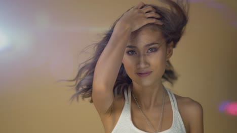 Stunning-Asian-model-posing-against-a-beige-background-with-anamorphic-light-leak-and-lens-flare-adding-glamour