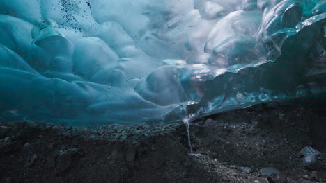 Close-up-inside-Blue-Ice-Cave-and-flowing-water-through-hole-inside-iceberg-glacier---Iceland,Europe