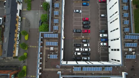 Aerial-view-above-energy-efficient-high-rise-solar-panel-rooftop-with-private-carpark-dolly-right-shot