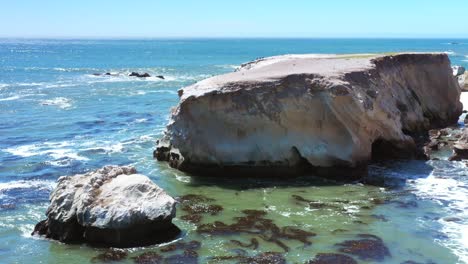 Gentle-ocean-waves-swelling-along-a-rocky-shoreline-in-Southern-California-on-a-sunny-day