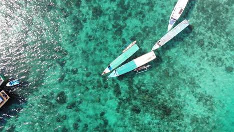 Luftaufnahme-Von-Traditionellen-Booten-Auf-Kristallklarem-Türkisfarbenem-Wasser-In-Indonesien