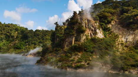 Dramatic-scene-of-boiling-Frying-Pan-Lake-surrounded-by-green-mountain-cliff-in-Waimangu,New-Zealand