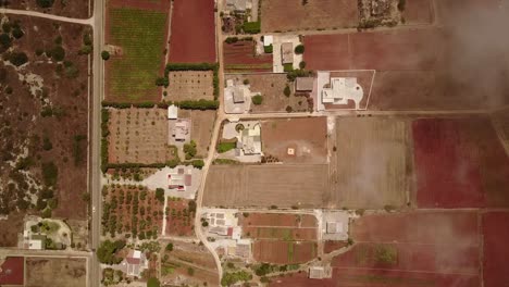 Top-view-by-drone-of-fields-in-Italy,-Puglia-with-clouds-flying-past