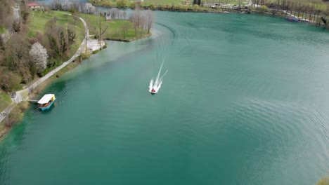 Aerial-shot-of-firefighters-on-urgent-ride-in-motorboat-on-lake-on-spring-day
