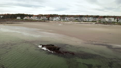 Schöne-Luftaufnahme-Von-Wellen,-Die-über-Die-Felsen-An-Einem-Kleinen-Strand-In-Maine-Krachen