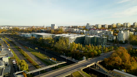 Aerial---Empty-roads-on-bridge,-expressway-and-railroad-near-Pomeranian-Science-and-Technology-Park-Gdynia-buildings-at-sunrise-in-Autumn