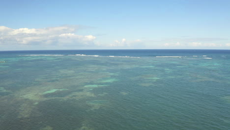 Shallow-caribbean-sea-waters-and-deep-ocean-behind-reef,-drone-shot