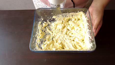 Mujer-Latina-Usando-Un-Delantal-Preparando-Cocinar-Horneando-Un-Pastel-Mezclando-La-Mantequilla-Con-Una-Batidora