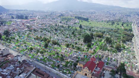 Drone-aerial-footage-of-urban-colonial-graveyard-cemetery-burial-grounds-churchyard-Cementerio-General-in-Central-American-highlands-city-Quetzaltenango,-Xela,-Guatemala-on-a-partly-cloudy-day