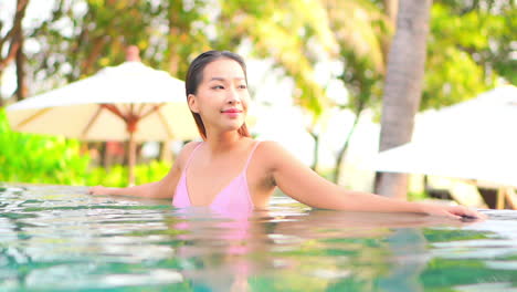 Portrait-of-Happy-Sexy-Asian-Woman-in-Swimming-Pool-at-Tropical-Vacation-on-Hot-Sunny-Day,-Full-Frame