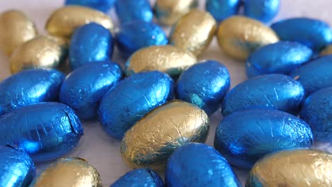 Osterei-Pralinen,-Eingewickelt-In-Glänzende-Blaue-Und-Gelbe-Wraps