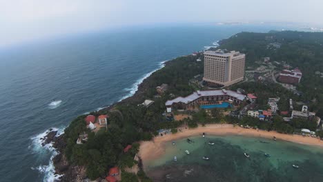 FPV-Amazing-Pull-Back-Shot-Of-Stunning-Hotel-Landscape-Surrounding,-Blue-ocean-Green-Trees,-Sri-Lanka