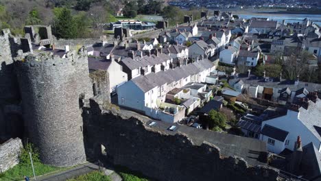 Welsh-holiday-cottages-enclosed-in-Conwy-castle-stone-battlements-walls-close-up-aerial-view-pan-right