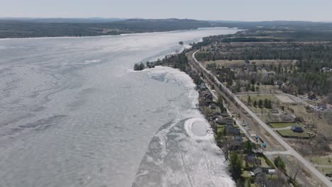 Charming-Residential-Houses-Lined-Up-On-The-Coast-Of-Lake-Magog-In-Alberta,-Canada---aerial-shot