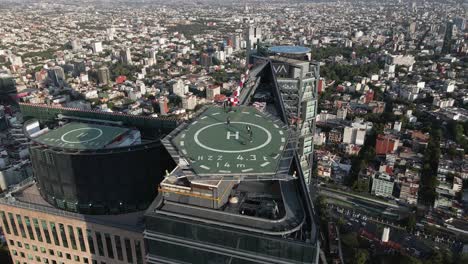 Toma-De-Drones-De-Alta-Velocidad-Del-Helipuerto-Más-Grande-De-La-Ciudad-De-México,-Vista-Aérea-Panorámica-De-Una-Torre-De-La-Ciudad-De-México,-En-El-Fondo-Del-Bosque-De-Chapultepec