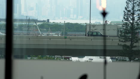 buses,-trucks-and-cars-passing-over-the-flyover,-view-from-the-restaurant-window