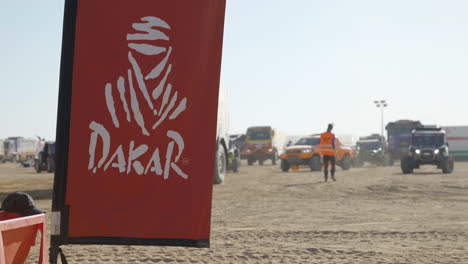 Vehículos-En-El-Campamento-De-Rally-Dakar-Con-El-Logo-Del-Rally-Dakar-En-Primer-Plano