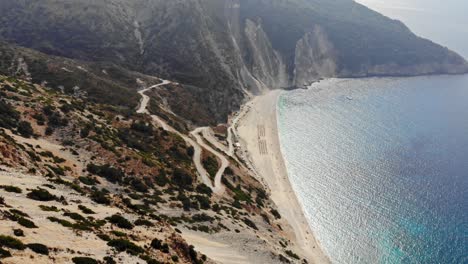 Winding-Road-And-White-Sand-At-Myrtos-Beach-As-Seen-From-The-Mountaintop-In-Kefalonia,-Greece