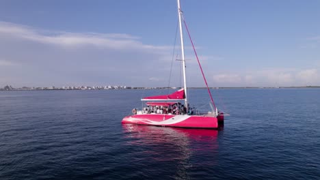 Zoom-Aéreo-De-Personas-Que-Celebran-Una-Boda-En-Un-Velero-Catamarán-Rojo