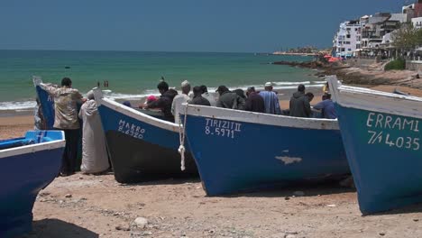 Men-gathering-around-the-catch-of-the-day-in-Taghazout-beach