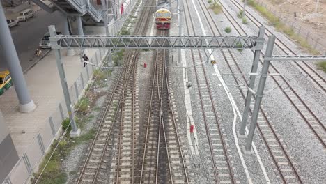 Antiguo-Tren-O-Tranvía-Local-Tailandés-En-El-Ferrocarril-Con-Torre-De-Postes-De-Servicios-Públicos-Y-Cables-En-Una-Estación-Terminal-En-Una-Ciudad-Urbana-En-Transporte-Público,-Tecnología-Eléctrica-De-Energía