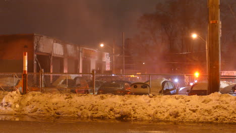 Blinking-emergency-lights-of-firefighter-team-near-burn-building,-night-time