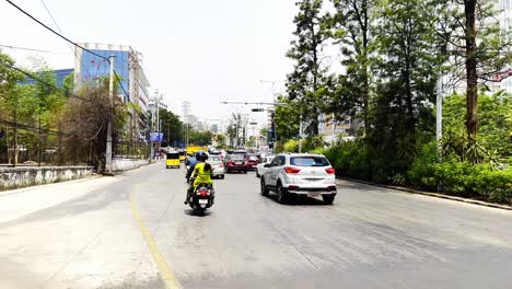 A-static-shot-of-traditional-Indian-moto-rickshaw-taxi-running-of-the-street-along-with-other-vehicle