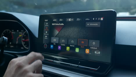 Driver's-Hand-Shifting-From-Sport-Drive-To-Eco-Drive-Mode-On-The-Car-Screen