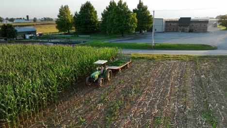 Niños-En-Tractor-John-Deere-Y-Vagón-Cosechan-Maíz-En-Escena-Aérea-De-Otoño