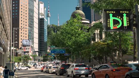 Seoul-city-life-with-a-view-of-iconic-N-Seoul-Tower-in-the-old-town-on-a-summer-day,-cars-stopped-on-the-red-traffic-lights-at-crossroads