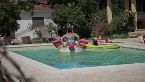Family-Having-Fun-Riding-Floaties-At-The-Pool-In-Summer---slow-motion