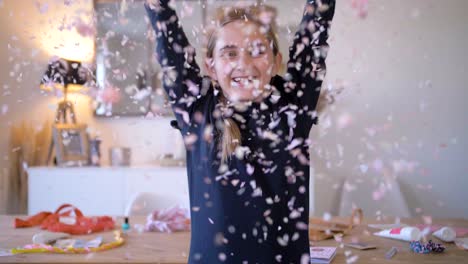 Happy-smiling-young-girl-throwing-confetti-into-air-at-home-in-slow-motion,close-up