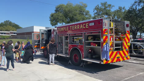 Evento-Familiar-Público-Con-Camión-De-Bomberos-En-La-Estación-De-Bomberos-De-Temple-Terrace-Florida,-Personas-Visitantes-Que-Obtienen-Experiencia-Práctica-Con-El-Equipo-De-Vehículos-De-Extinción-De-Incendios