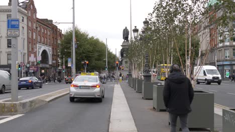 Vehicles-Driving-At-O'Connell-Bridge-with-Daniel-O'Connell-Monument-In-Ireland