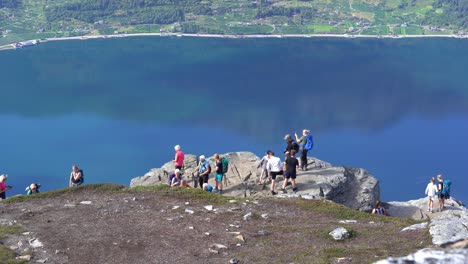 Multitud-De-Personas-Están-Tomando-Fotos-Y-Usando-Las-Redes-Sociales-En-La-Ruta-De-Senderismo-Dronningstien-Queens-Entre-Lofthus-Y-Kinsarvik-En-Noruega---Fondo-De-Hardangerfjord---Portátil-Estático