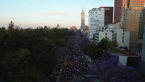 Demonstration-parade-for-female-rights-in-Mexico-city,-during-sunset---Aerial-view