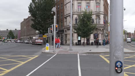 Pedestrians-And-Traffic-In-The-Street-With-O'Connell-Bridge-House,-Heineken-Building-In-Dublin,-Ireland